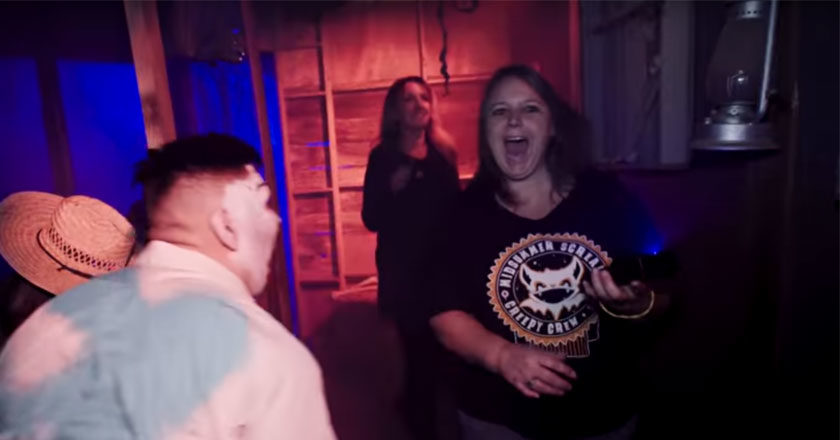Woman scared by a monster walking through a home haunt in the Epic Home Haunts documentary