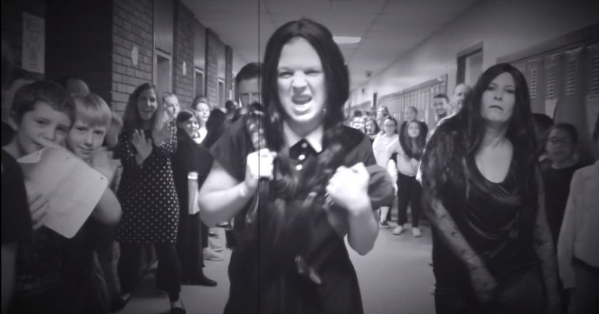 Faculty members of Abigail Adams Middle School perform amidst a hall full of students