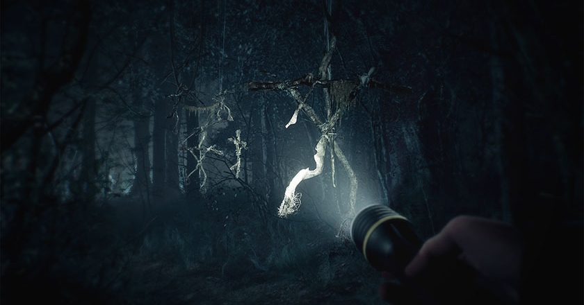 Blair Witch game screenshot with a flashlight illuminating a totem