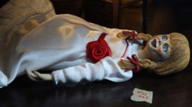 Clothed Annabelle doll lying on the ground