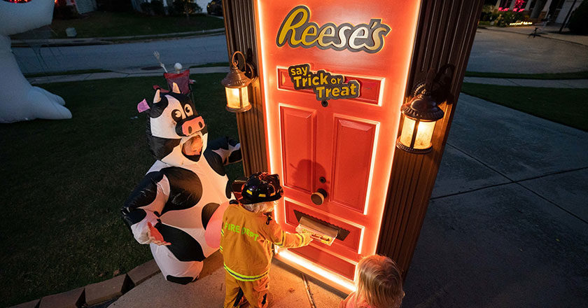 Children collecting candy from the Reese's Trick-or-Treat Door