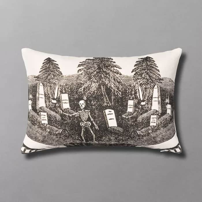 Printed lumbar pillow featuring a graveyard graphic featuring a skeleton