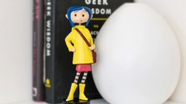 Coraline in rain coat bobble figure on a shelf