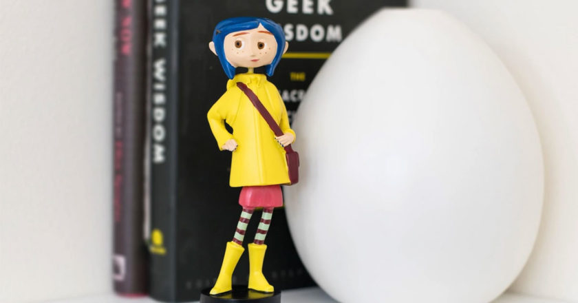 Coraline in rain coat bobble figure on a shelf