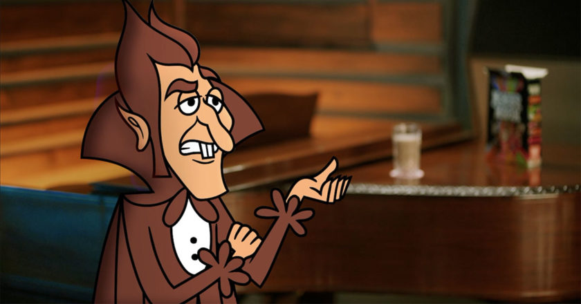 Count Chocula sitting in front of a piano