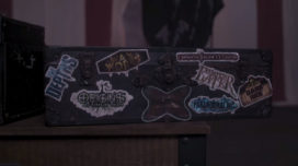 The conductor's suitcase covered in stickers of each of the 2021 returning Knott's Scary Farm maze logos