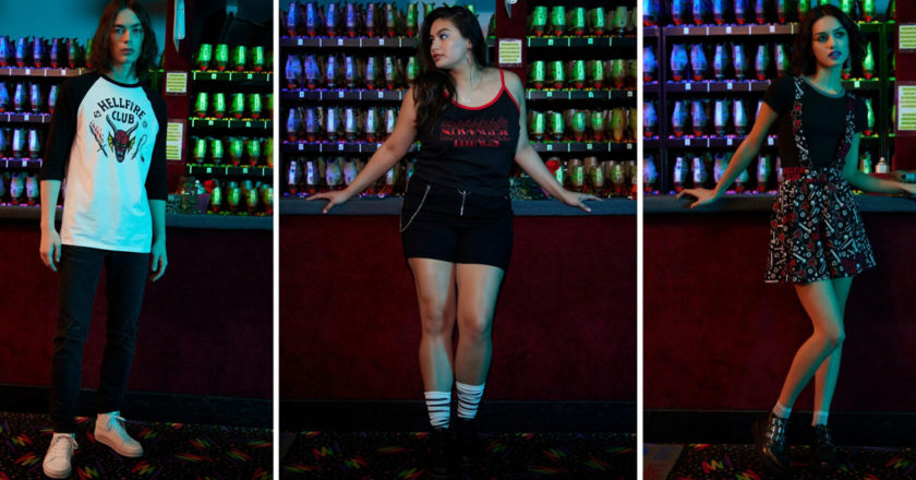 A male model in a Hellfire Club raglan, a female model in a "Stranger Things" logo black cami, and a female model in a "Stranger Things" themed suspender skirt