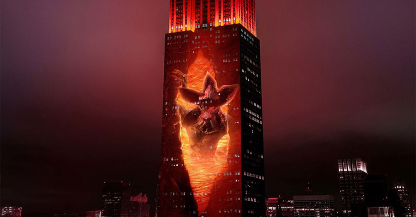 A Demogorgon appears out of a rift projected on the Empire State Building