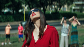 Ilenia Pastorelli looks up at an eclipse while wearing dark sunglasses in "Dark Glasses"