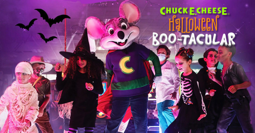 Chuck E. Cheese dancing with kids in Halloween costumes