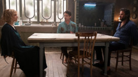 Guido Caprino, Camilla Filippi, and Edoardo Pesce sit at a kitchen table in "The Guest Room (La Stanza)"
