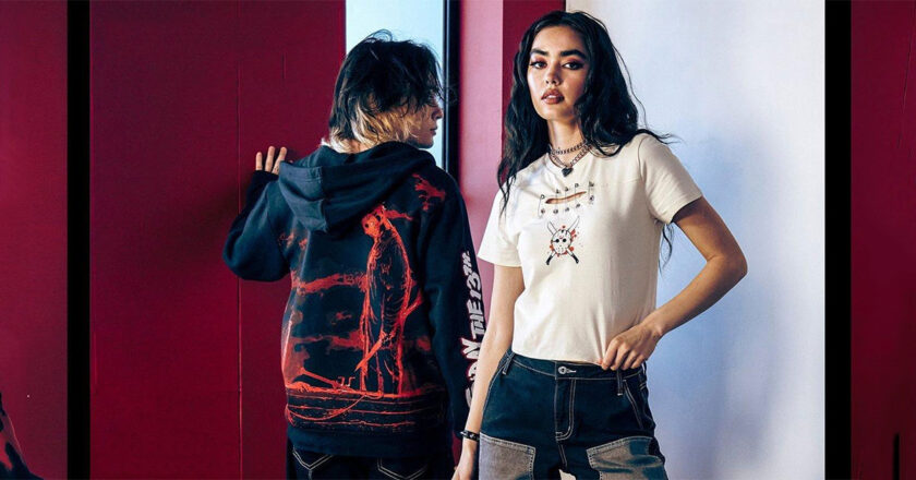 A male model with his back turned revealing the back of Hot Topic's Friday The 13th Jason Tonal Hoodie and a female model wearing the Friday The 13th Jason Mask Cutout Girls Baby T-Shirt