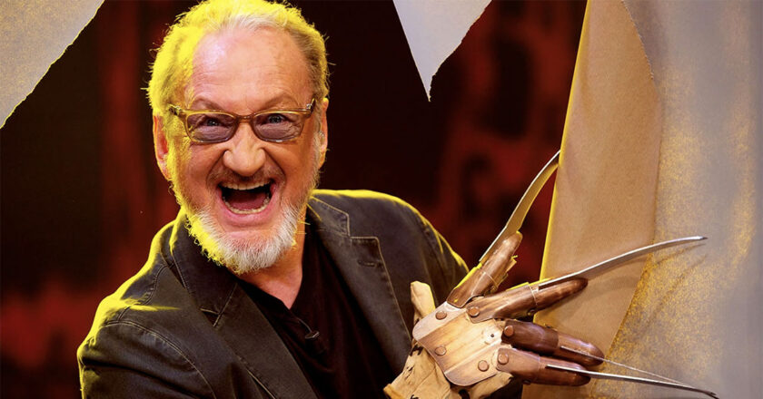 Robert Englund wearing the Freddy Krueger glove and tearing through a piece of cloth