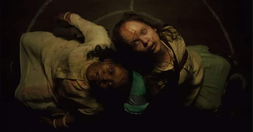 Lidya Jewett and Olivia Marcum as possessed young girls sitting back to back looking into the air in "The Exorcist: Believer."
