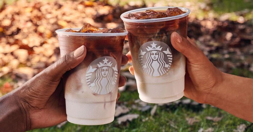 Two people holding Starbucks fall beverages