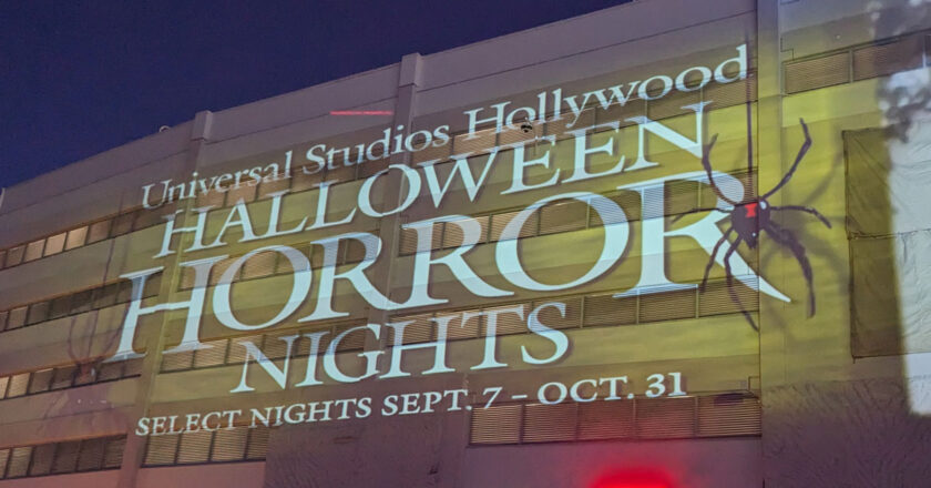Universal Studios Hollywood Halloween Horror Nights logo with a spider on it being projected on a building