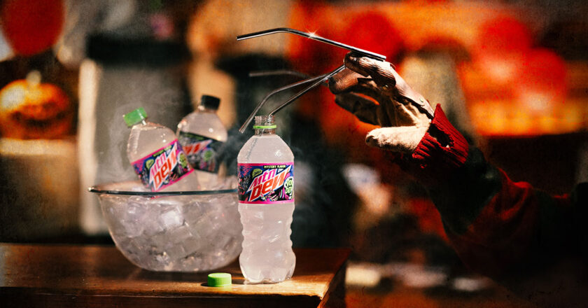 A clawed hand reaches for a bottle of MTN DEW VOO-DEW
