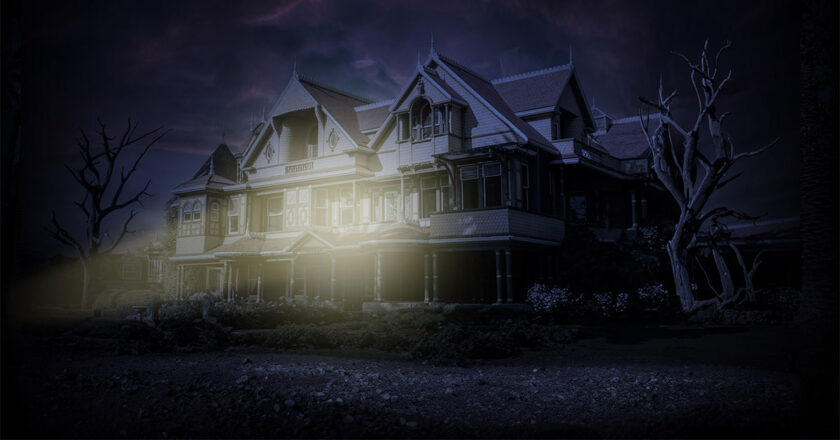The exterior of the Winchester Mystery House being illuminated by a flashlight at night