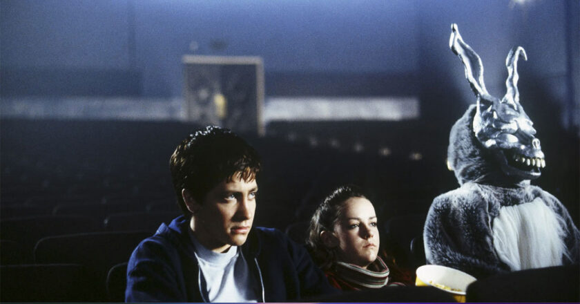 Jake Gyllenhaal and Jena Malone sit in a theater next to Frank the Rabbit in "Donnie Darko."