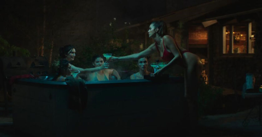 Five models in a hot tub at night from "Model House"