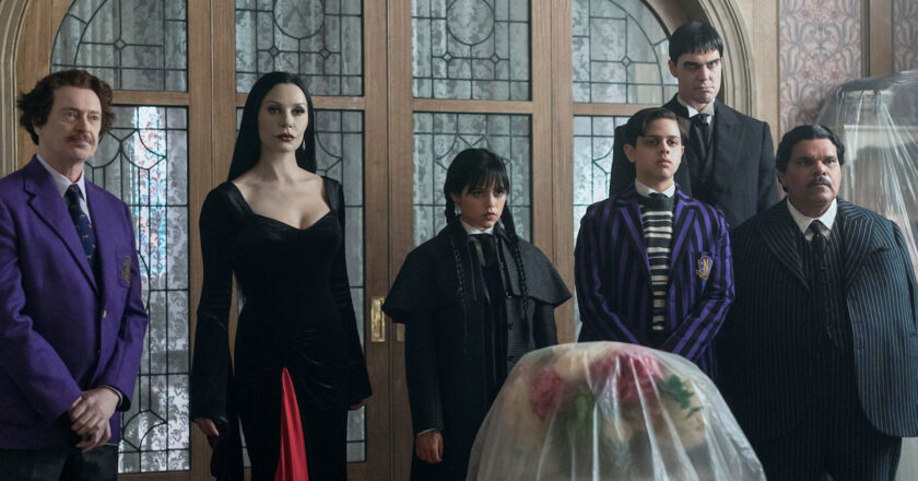 Steve Buscemi as Principal Dort, Catherine Zeta Jones as Morticia Addams, Jenna Ortega as Wednesday Addams, Isaac Ordonez as Pugsley Addams, Joonas Suotamo as Lurch, and Luis Guzmán as Gomez Addams in Season 2 of Wednesday.
