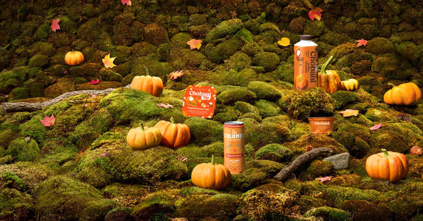 Pumpkin Spice Greek Yogurt, Pumpkin Harvest Crisp Flip, Pumpkin Spice Coffee Creamer, and La Colombe Draft Latte, Pumpkin Spice on a mossy hill surrounded by pumpkins.