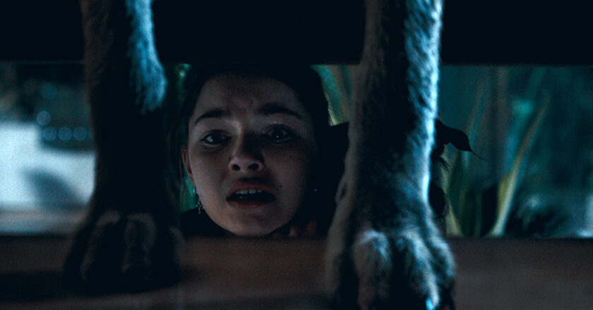Mila Harris as Chloe hides under the stairs from a coyote in "Coytes"